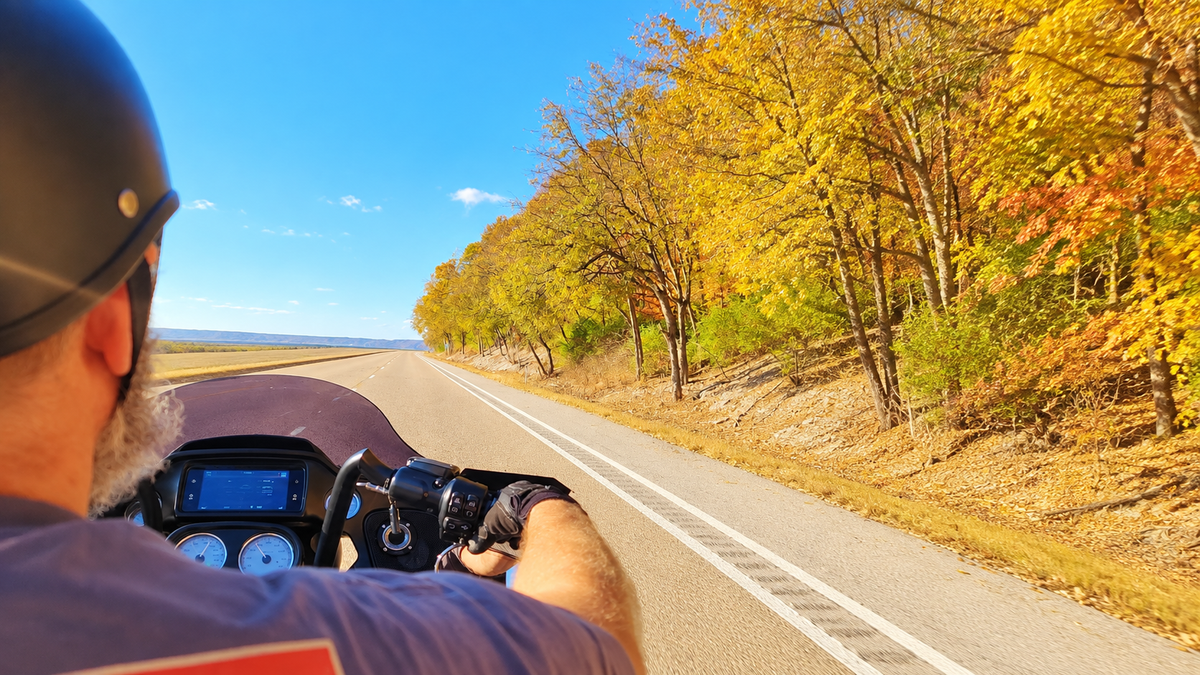 Motorcycle rider heading north on the Great River Road toward Grafton, Illinois, during fall